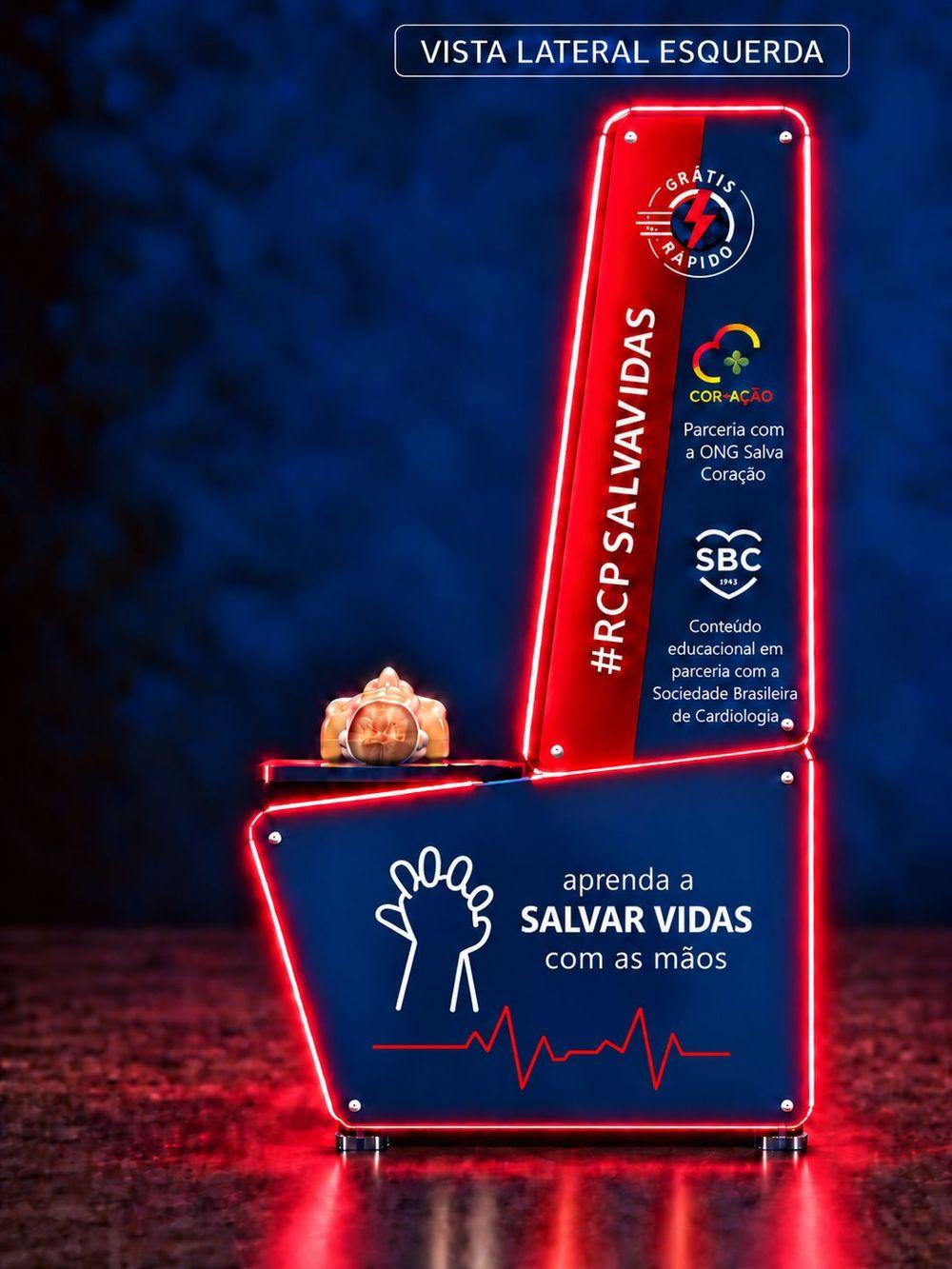 Vista lateral esquerda do totem Elysium CPR — Selos Cor+Ação e Sociedade Brasileira de Cardiologia